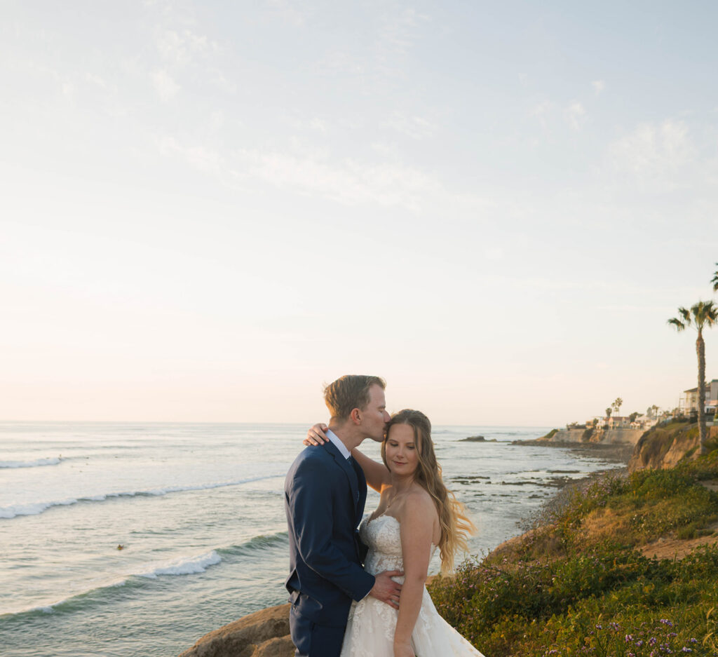 Intimate beach elopement ceremony with family gathered on a cliffside