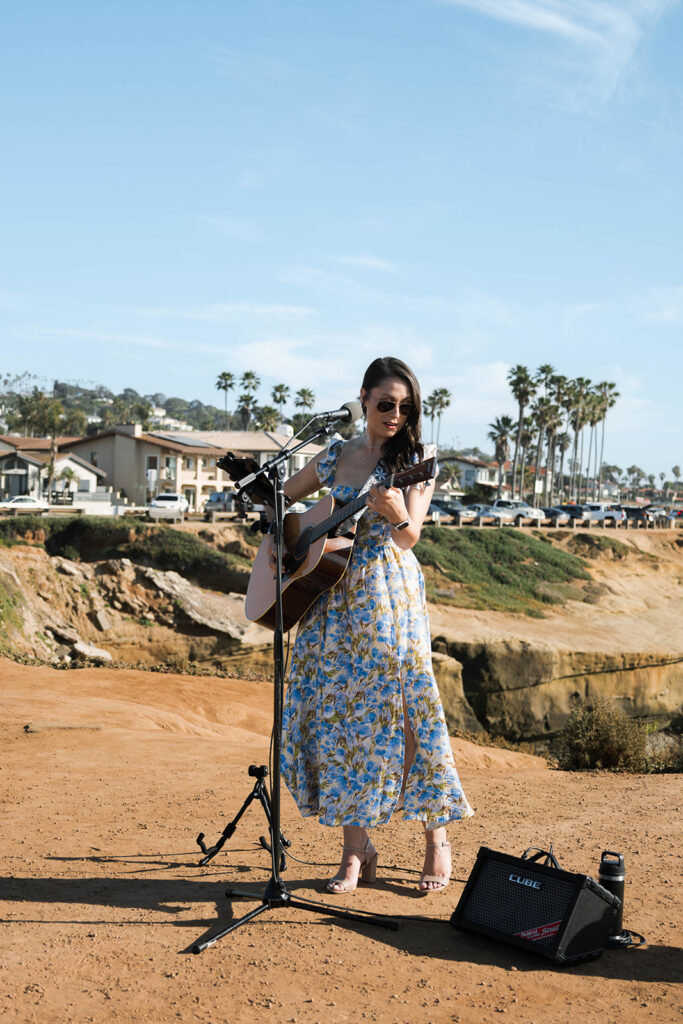 Intimate cliffside elopement ceremony overlooking the ocean at sunset