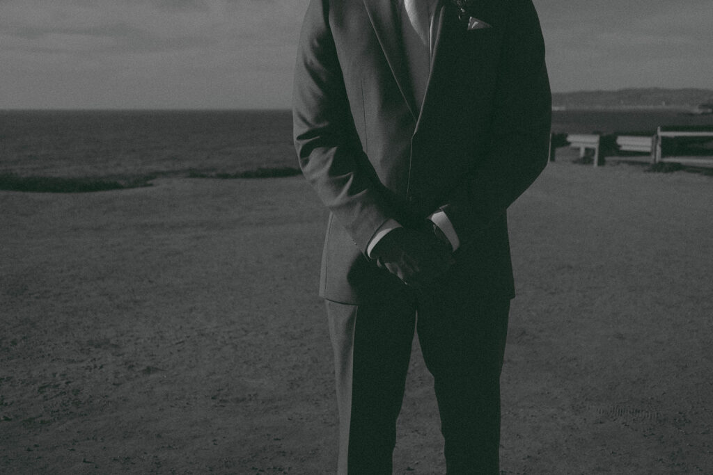 Intimate cliffside elopement ceremony overlooking the ocean at sunset