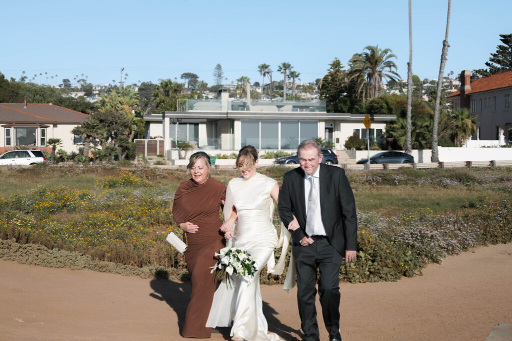 Intimate cliffside elopement ceremony overlooking the ocean at sunset