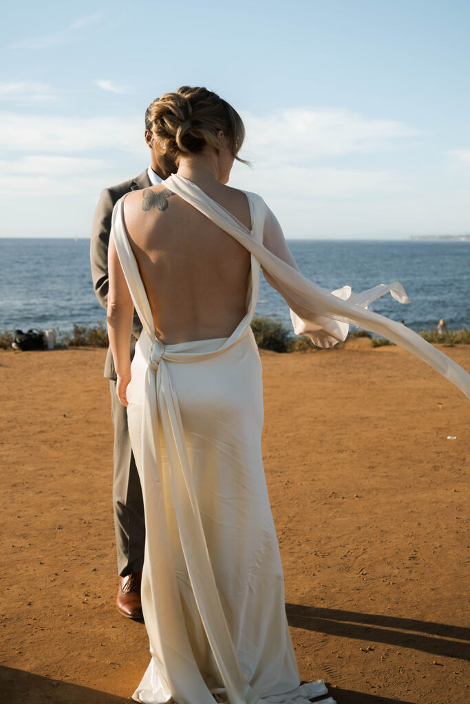Intimate cliffside elopement ceremony overlooking the ocean at sunset