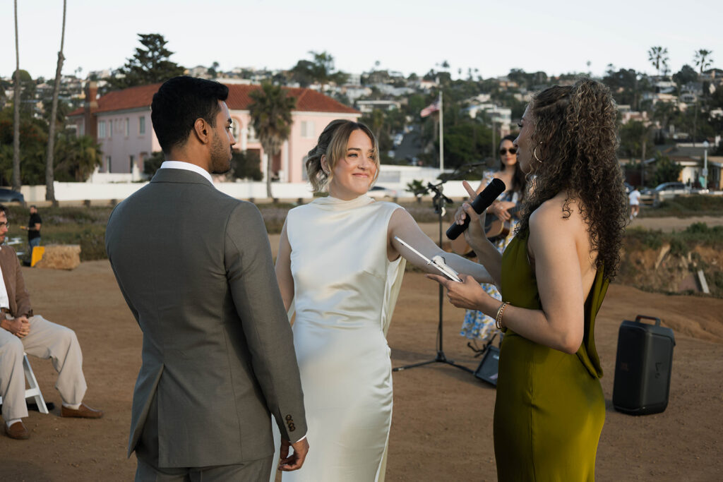 Intimate cliffside elopement ceremony overlooking the ocean at sunset