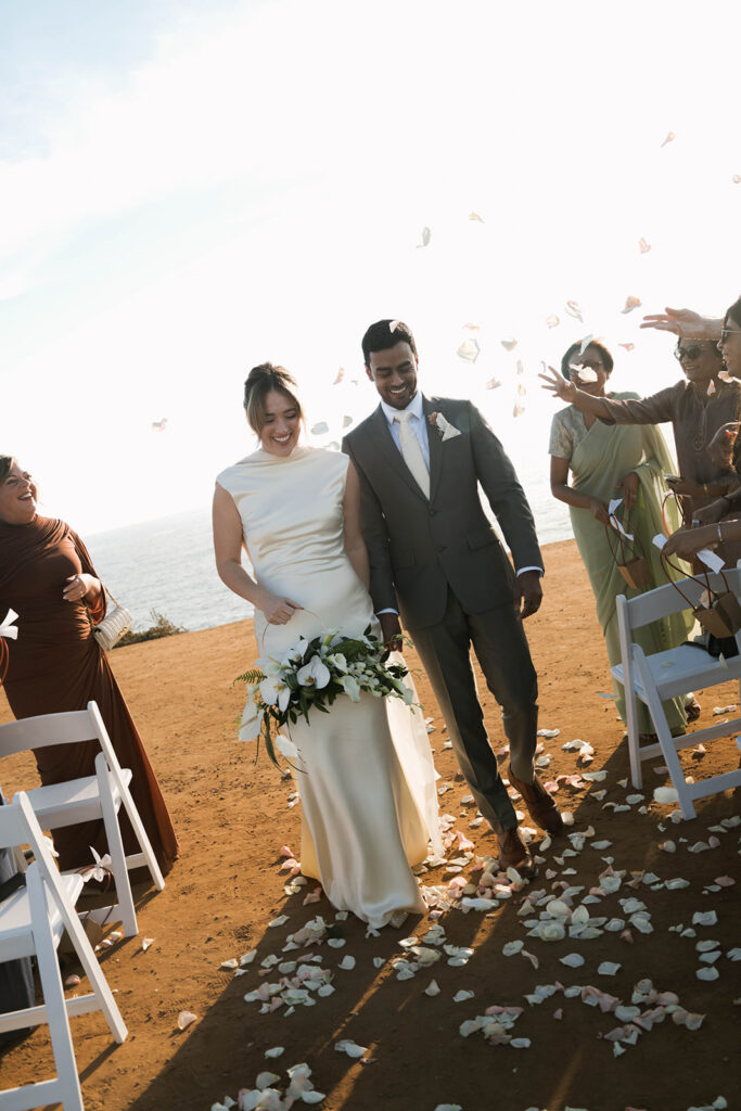 Intimate cliffside elopement ceremony overlooking the ocean at sunset