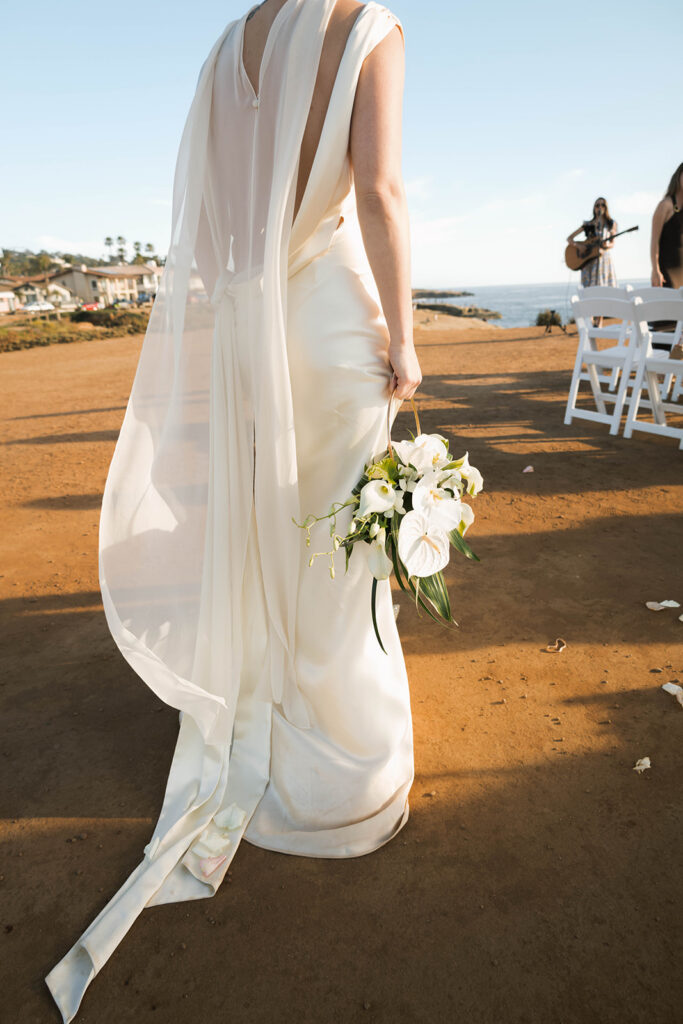 Intimate cliffside elopement ceremony overlooking the ocean at sunset