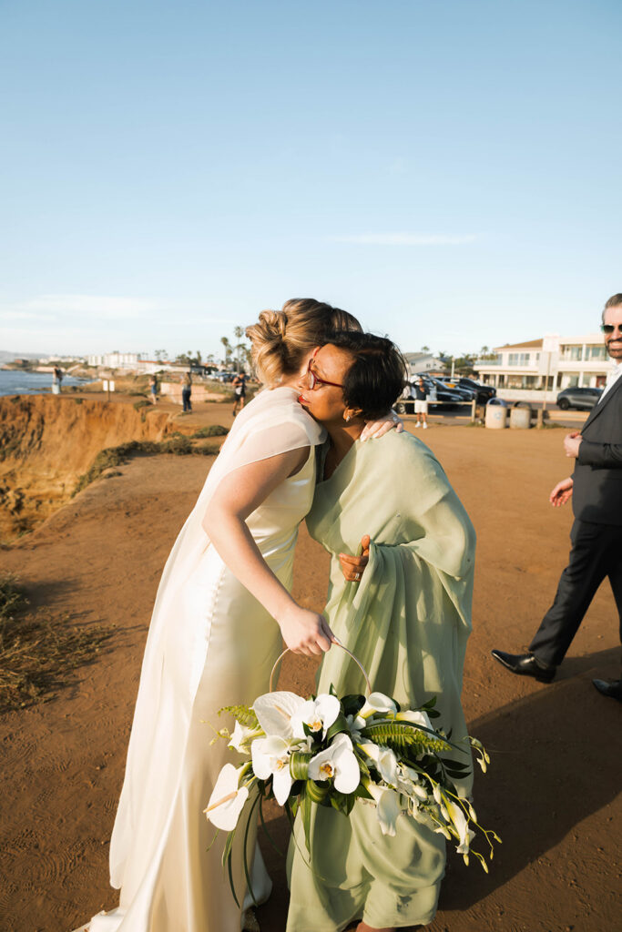 Intimate cliffside elopement ceremony overlooking the ocean at sunset