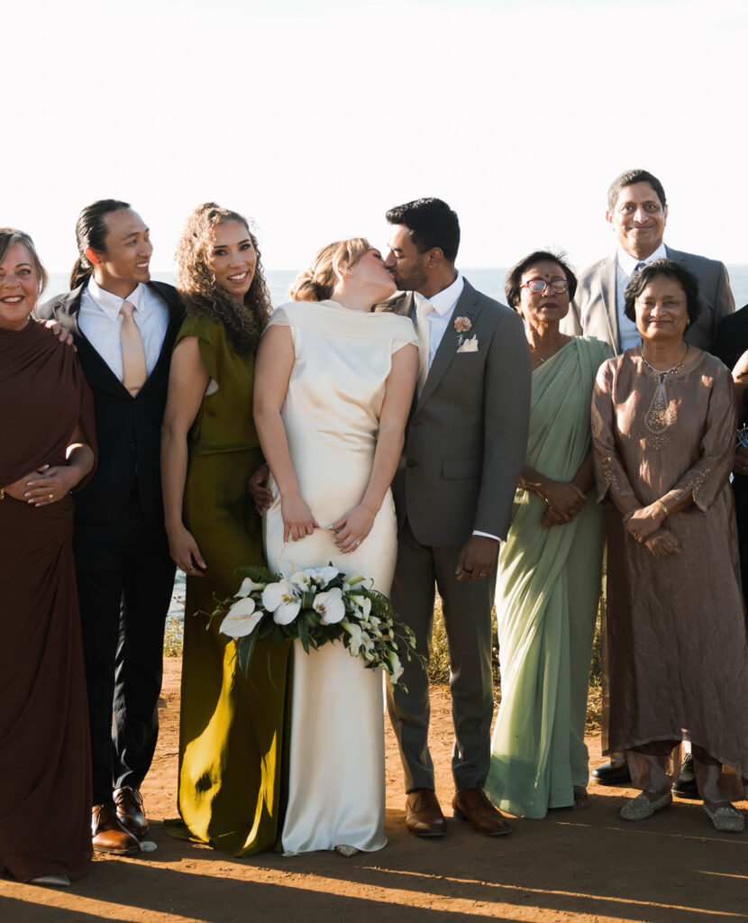 Intimate cliffside elopement ceremony overlooking the ocean at sunset