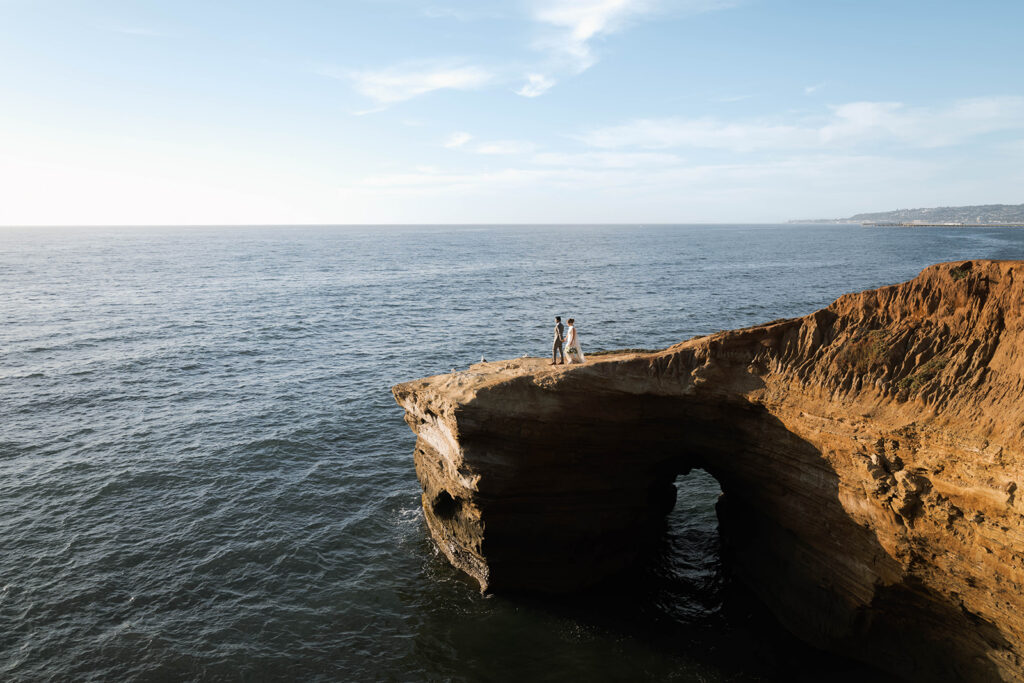 Intimate cliffside elopement ceremony overlooking the ocean at sunset