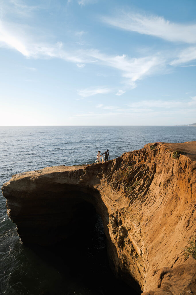 Intimate cliffside elopement ceremony overlooking the ocean at sunset