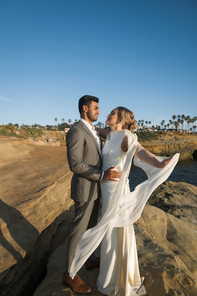 Intimate cliffside elopement ceremony overlooking the ocean at sunset