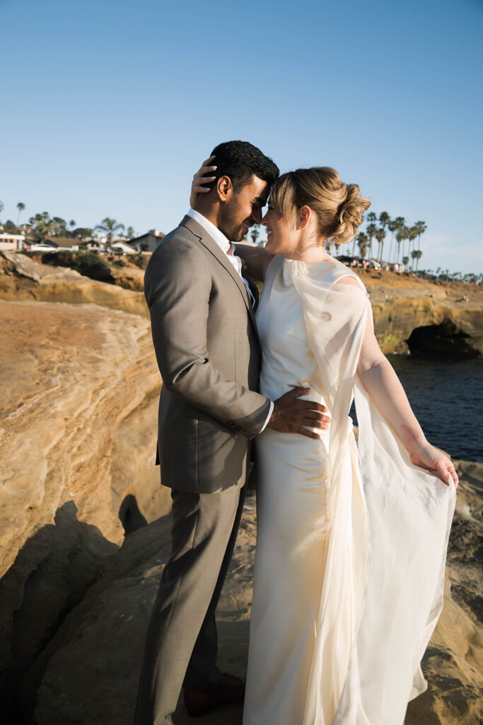Intimate cliffside elopement ceremony overlooking the ocean at sunset