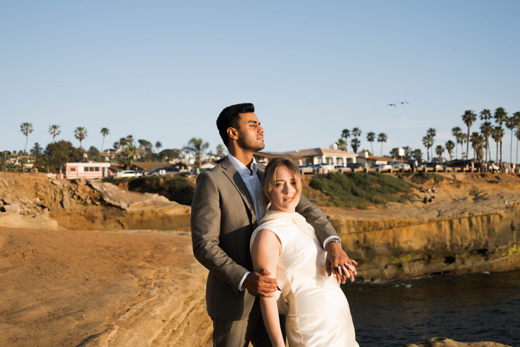 Intimate cliffside elopement ceremony overlooking the ocean at sunset