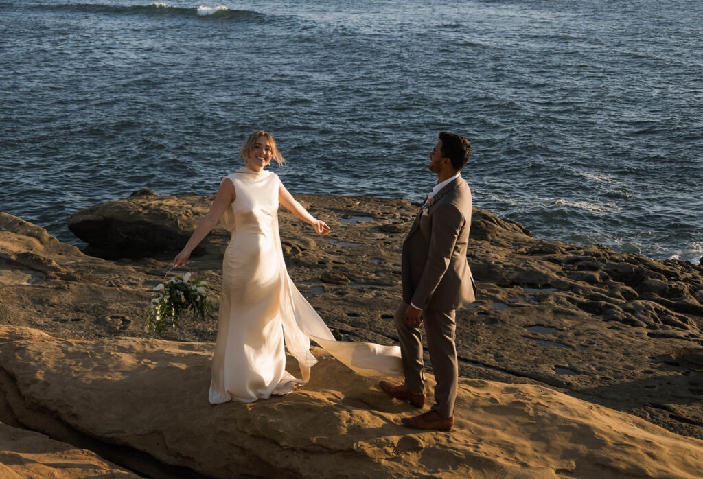 Intimate cliffside elopement ceremony overlooking the ocean at sunset
