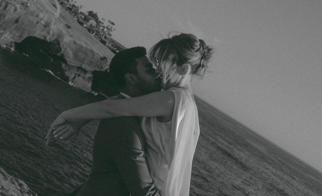 Intimate cliffside elopement ceremony overlooking the ocean at sunset
