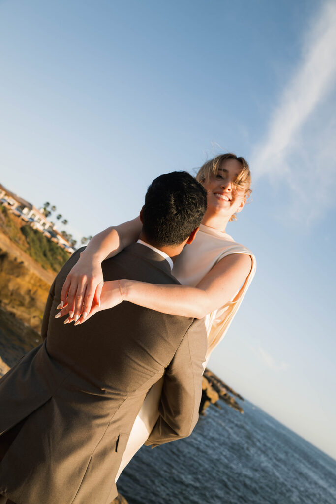 Intimate cliffside elopement ceremony overlooking the ocean at sunset