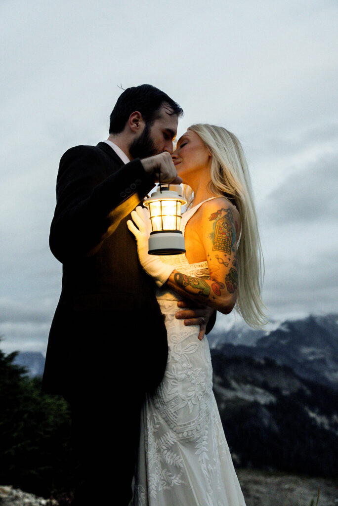 bride and groom portrait hugging with lantern at blue hour in the north cascades mountains of washington