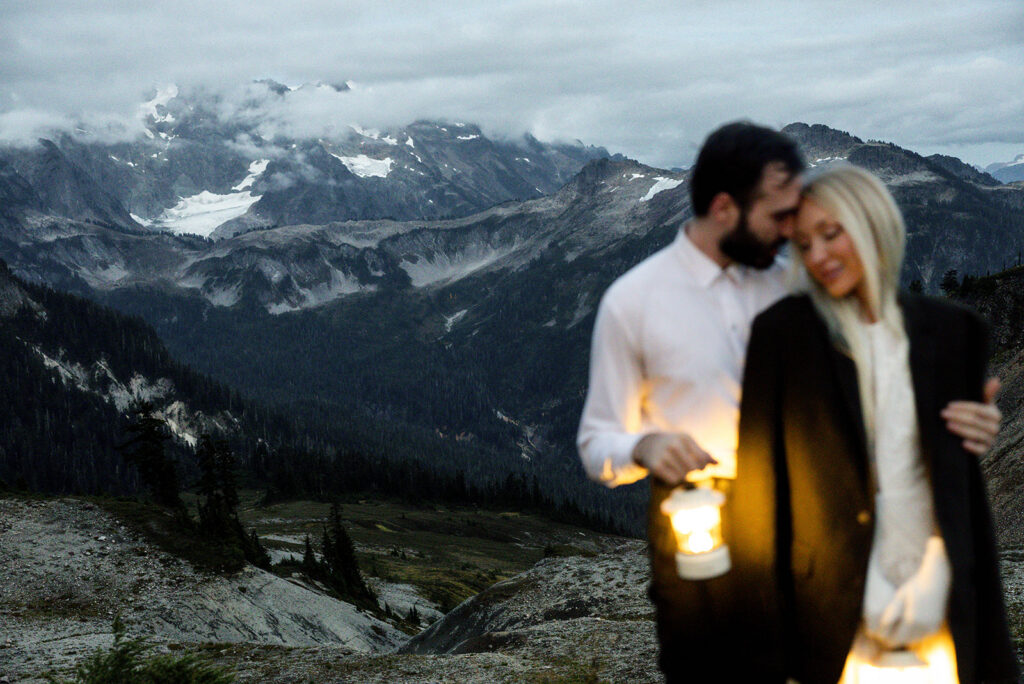 bride and groom portrait hugging with lantern during blue hour in the north cascades mountains of washington
