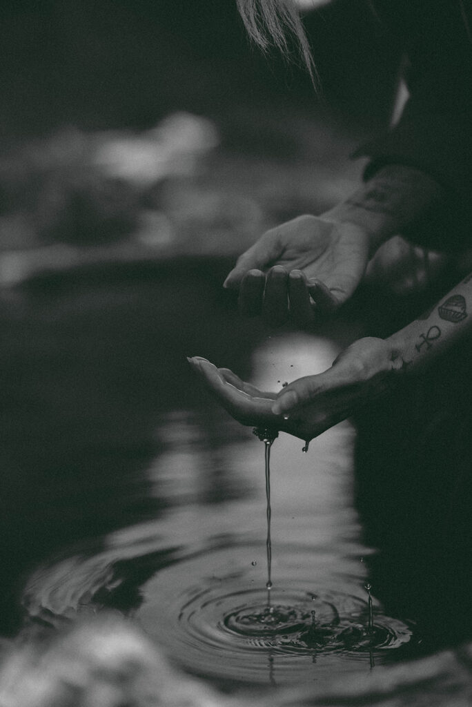 bride dripping water off ring in lake in the mountains of washington