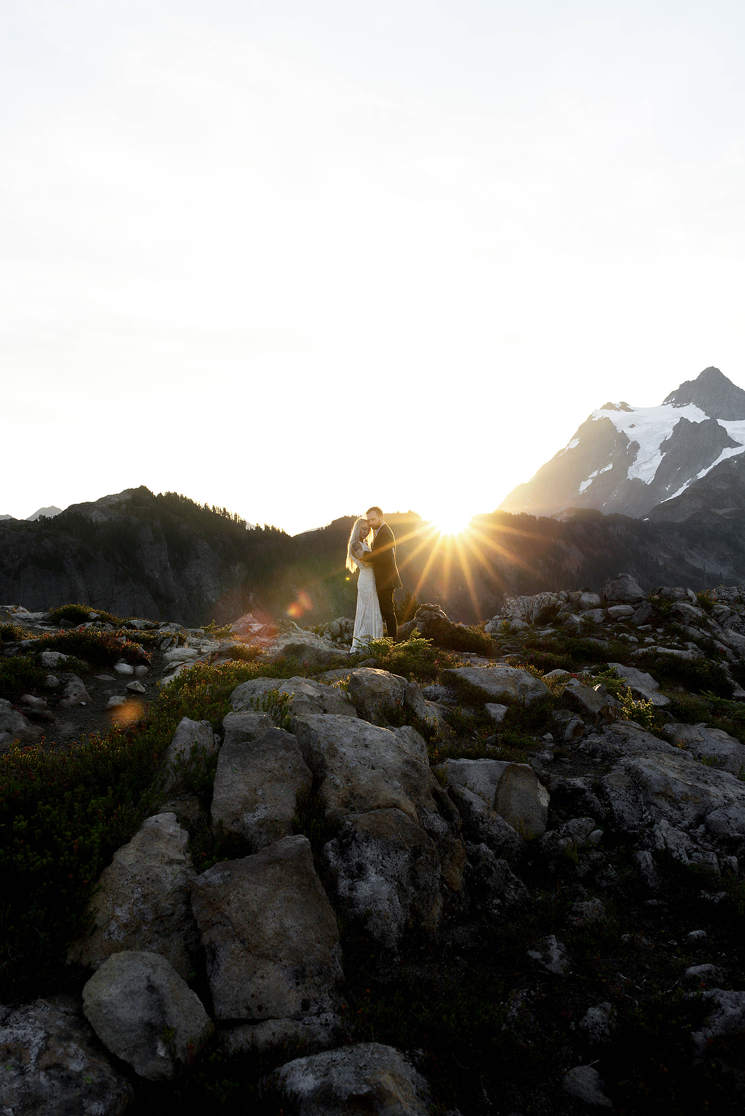 bride and groom embracing on a lake in the North Cascades mountains of Washington